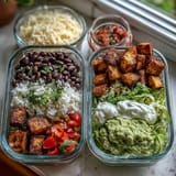 Vibrant meal prep burrito bowl base with fluffy rice, hearty black beans, and seasoned chicken ready for fresh toppings.