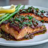 Garlic butter salmon with asparagus roasted to perfection on a sheet pan, garnished with fresh parsley and lemon slices.