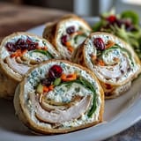 Colorful turkey and cheese pinwheel sandwiches, perfect for kids' lunchboxes or party platters.
