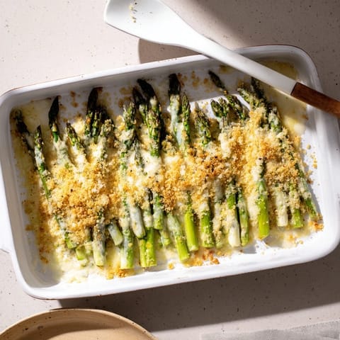 Sizzling, bubbly Asparagus Casserole coming out of the oven with a crunchy breadcrumb topping for spring.