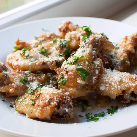 Crispy baked Garlic Parmesan Wings served hot on a platter with celery sticks and creamy ranch dressing.