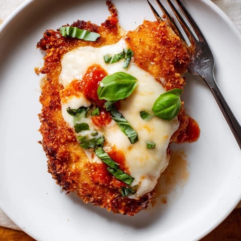 Crispy Chicken Parm Wrap served on a wooden board with a small bowl of marinara sauce for dipping alongside fresh basil.