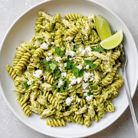 A close-up of Cilantro Lime Chicken Pasta with rotini, shredded chicken, and a bright cilantro-lime yogurt sauce.