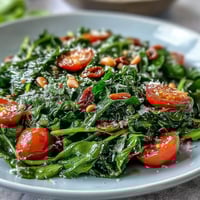 Vibrant dandelion greens salad with lemon vinaigrette and Parmesan shavings for a fresh Mediterranean starter.  